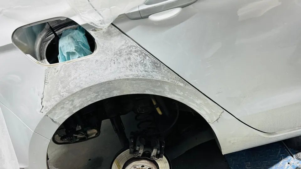 Vorbereitete hintere Seitenwand eines weißen Mercedes während der Instandsetzung